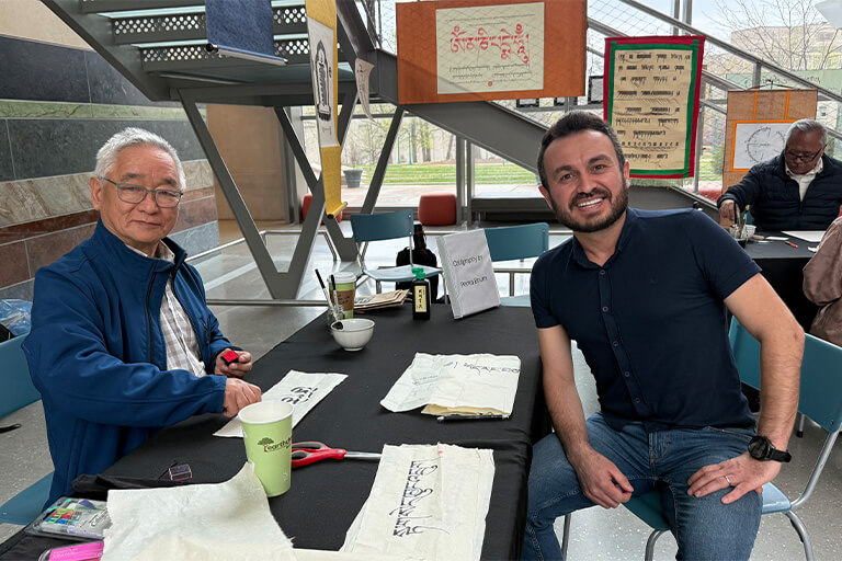 Öner Özçelik at a table in the HLS atrium.